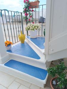 einen Balkon mit blauem Boden und einer gelben Vase in der Unterkunft M&G Maison in Crispiano