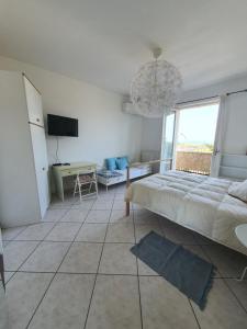a bedroom with a bed and a table and a television at NEL BLU in Porto SantʼElpidio