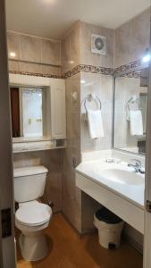 y baño con aseo blanco y lavamanos. en Hotel y Cabañas Lago Ranco - Caja los Andes en Futrono