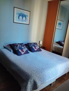 a bedroom with a bed with two pillows and a mirror at Le Nid - Studios in Chartres +19 photos