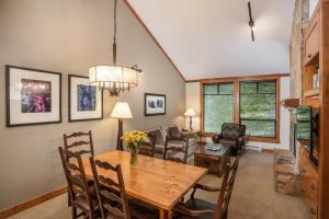 comedor con mesa de madera y sillas en First Tracks Lodge, en Whistler