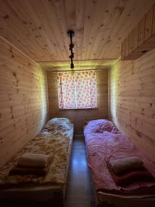 two beds in a room with a window at Nad Głuchym Potokiem in Rosochate +19 photos