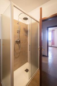 uma casa de banho com um chuveiro e uma porta de vidro em Nel tranquillo centro d'Isola em Isola di Fano