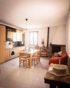 cocina con mesa, sillas y sofá en Nel tranquillo centro d'Isola en Isola di Fano