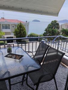 パレオ・ティフリキにあるVasilikiのテーブルと椅子、海の景色を望むバルコニー