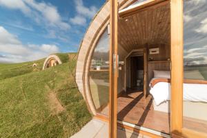 a bedroom in a dome house with a large window at Hares View in Rhayader