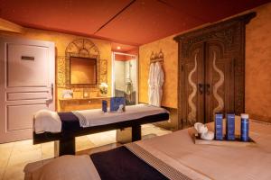 a bedroom with two beds and a bathroom at Le Manoir De La Poterie & Spa in Cricquebœuf