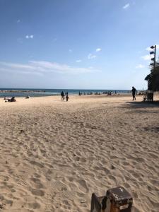 un gruppo di persone che camminano su una spiaggia di Rosabella Casa Vacanze a Bari