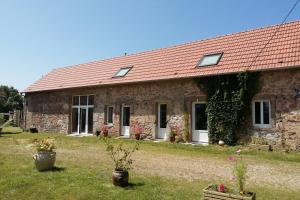 an old stone house with a red roof at Studio l'Eau de Bel Air in Droiturier