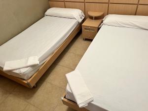 - deux lits jumeaux dans une chambre avec deux tables dans l'établissement Apartamentos Deluxe Marina Dor, à Oropesa del Mar