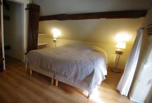 a bedroom with a bed with two lights on the wall at Gte Avec Piscine Sainte Anne in Ygrande