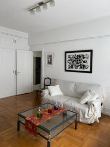 uma sala de estar com um sofá branco e uma mesa de vidro em Buenos Aires unique location em Buenos Aires