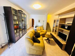 un salon avec un canapé jaune et une télévision dans l'établissement Villa Lisbona, à Ladispoli
