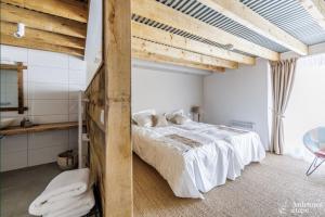 duas imagens de um quarto com uma cama e uma mesa em Ancien Moulin de Neffe em Bastogne
