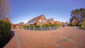 a red brick road with houses and a peace sign on it at Strandbox & Strandresidenz in Norderney