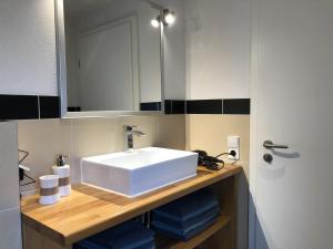 uma casa de banho com um lavatório branco e um espelho. em Waldmomente em Schauren