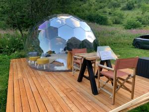 a bed in a soccer ball dome on a wooden deck at The Lynx in Salvan