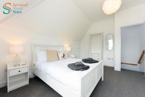 a white bedroom with a white bed and a mirror at Bella, two bedroom apartment close to the beach in Margate