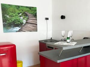 eine Küche mit roten Schränken und einem Wandgemälde in der Unterkunft Ferienwohnung Dittmar am Kaffeehof in Bad Liebenzell