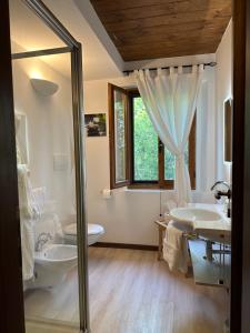 een badkamer met 2 wastafels, een toilet en een douche bij Agriturismo Akasha in Branca