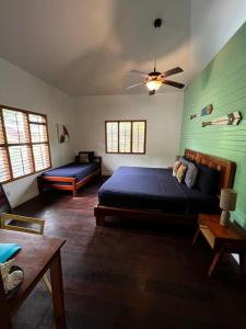 1 dormitorio con 1 cama y ventilador de techo en Turtle Beach House, en Bocas Town