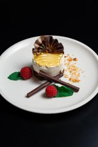 a piece of cake on a white plate with raspberries at Hotel California by Aycon in Sveti Stefan