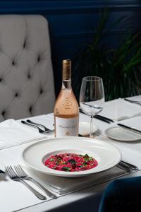 a bottle of wine and a plate of food on a table at Hotel California by Aycon in Sveti Stefan