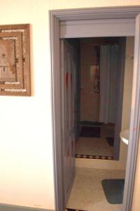 - une porte menant à une salle de bains pourvue d'une douche et d'un miroir dans l'établissement Lot 46, à Souira Guedima