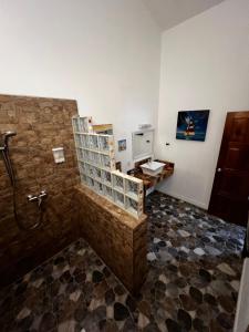 a bathroom with a shower with a stone wall at Turtle Beach House in Bocas del Toro