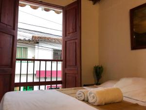 um quarto com uma cama e uma janela com toalhas em apartasuite Centro Historico em Santa Fe de Antioquia