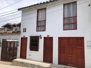 Casa blanca con puertas y ventanas de madera en apartasuite Centro Historico en Santa Fe de Antioquia