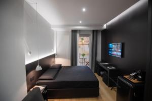 een slaapkamer met een bed, een bureau en een televisie bij Contemporaneamente 147 - Modern & Comfort Rooms in Bari