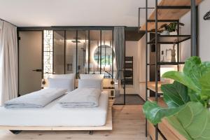 una camera con un letto bianco e una parete di vetro di Grand Pension Franziska - inkl CrossFit Gym a Saalbach Hinterglemm