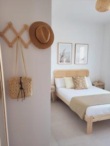 a bedroom with two beds and a hat on the wall at ÁTICOS ROTA Punta Candor in Rota