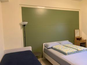 a bedroom with a green headboard and a bed at Duke 369 in Donggang