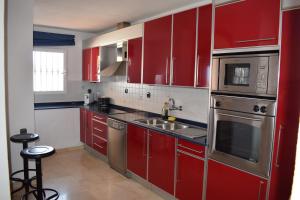 a kitchen with red cabinets and a sink at Duplex con vistas mijas Golf in Mijas