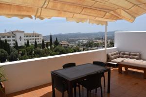 a balcony with a table and chairs and an umbrella at Duplex con vistas mijas Golf in Mijas