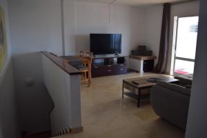 a living room with a couch and a tv at Duplex con vistas mijas Golf in Mijas