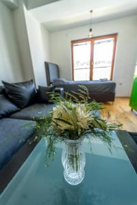 a vase with flowers sitting on a glass table at Petar Apartment, Ohrid in Ohrid