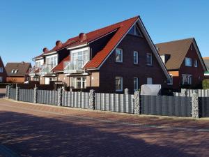 una casa con una valla delante de ella en Strandbox & Strandresidenz en Norderney