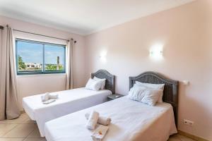 two beds in a room with a window at #166 Frat Apartment by Home Holidays in Albufeira +46 photos