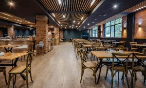 a restaurant with tables and chairs and a bar at Bakuriani Inn in Bakuriani