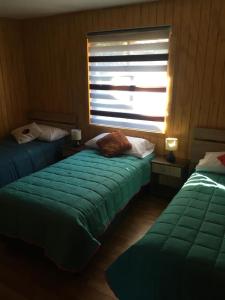 Een bed of bedden in een kamer bij cabañas anvi pucon