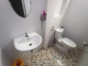 een badkamer met een wastafel, een toilet en een spiegel bij Nhà nghỉ PHƯƠNG HIỀN in Vung Tau