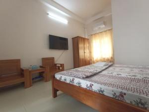 1 dormitorio con 1 cama y TV de pantalla plana en Nhà nghỉ PHƯƠNG HIỀN, en Vung Tau