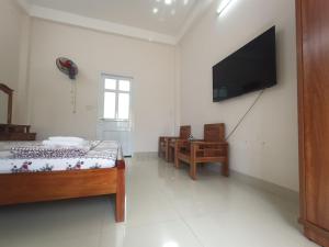 1 dormitorio con 2 camas y TV de pantalla plana en Nhà nghỉ PHƯƠNG HIỀN, en Vung Tau