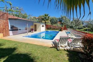 a backyard with a swimming pool and two chairs at Vila Azul in Amarante