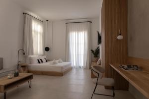 a bedroom with a bed and a table and a chair at enδόtera chios apartments in Chios