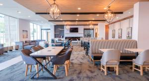 un comedor con mesas, sillas y lámparas de araña en La Quinta Inn & Suites by Wyndham Austin Parmer Tech Ridge en Austin