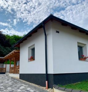 a white building with two windows and a blue roof at White Luxury Cottage- Mátrai Vadászház 4 in Mátraterenye